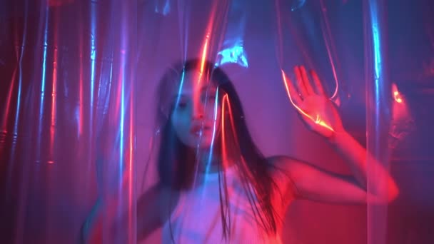 młoda azjatycka kobieta pozowanie w pobliżu polietylenu na neon niebieski i różowy - Materiał filmowy, wideo