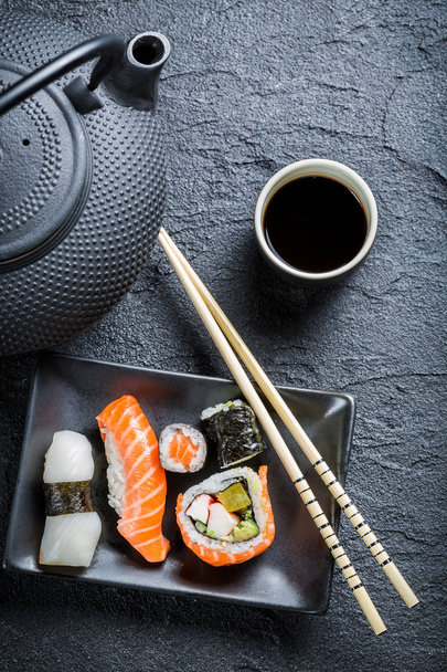 verse sushi geserveerd in een zwarte keramische - Foto, afbeelding