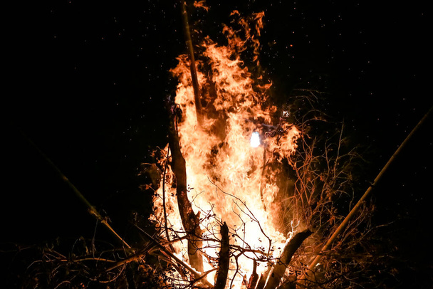 Вогонь з дровами на землі червоне полум'я з чорним тлом з красивими іскрами
. - Фото, зображення