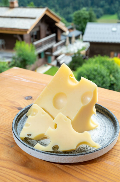 Peynir koleksiyonu, Fransız inek peyniri emmental ve yazın Haute-Savoie 'deki Fransız dağ köyü. - Fotoğraf, Görsel