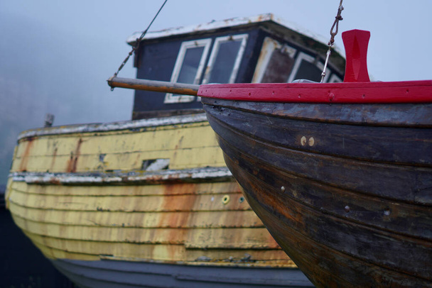 C'est une journée brumeuse et brumeuse à Hastings et les bateaux sont enveloppés dans la brume marine alors qu'ils se trouvent sur la plage de galets en attendant la prochaine marée haute.  - Photo, image