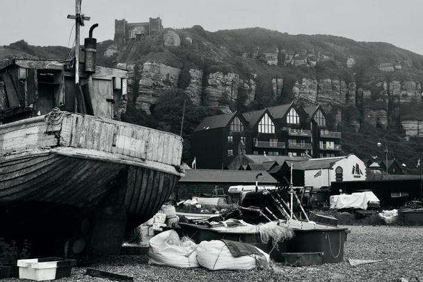 C'est une journée brumeuse et brumeuse à Hastings et les bateaux sont enveloppés dans la brume marine alors qu'ils se trouvent sur la plage de galets en attendant la prochaine marée haute.  - Photo, image