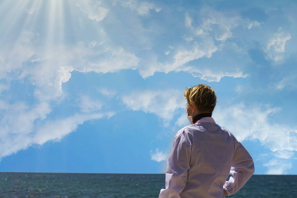 Vaalea lääkäri nainen Venäjän valkoihoinen ulkonäkö katselee pois sininen meri horisontti toivoa. Muotokuva ammatillinen luottavainen amerikkalainen lääkäri lääketieteellinen naamio ja valkoinen takki selkä kameraa kohti - Valokuva, kuva