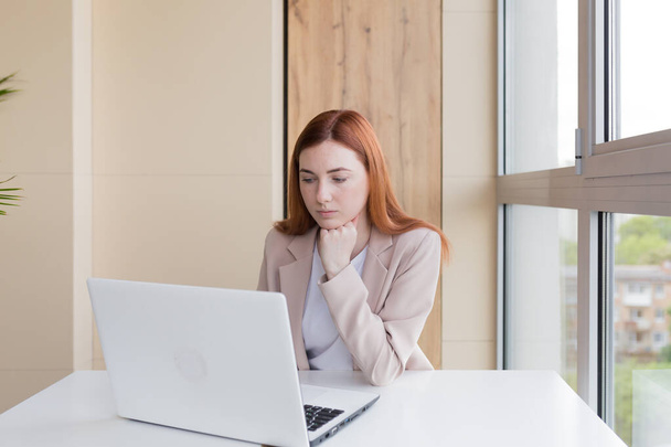 Serious business woman working on laptop sitting at office desk - Φωτογραφία, εικόνα