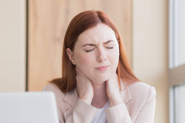 Nahaufnahme einer rothaarigen Geschäftsfrau mit starken Zahnschmerzen und Kopfschmerzen am Computer, Überlastung, Stress und Depressionen - Foto, Bild