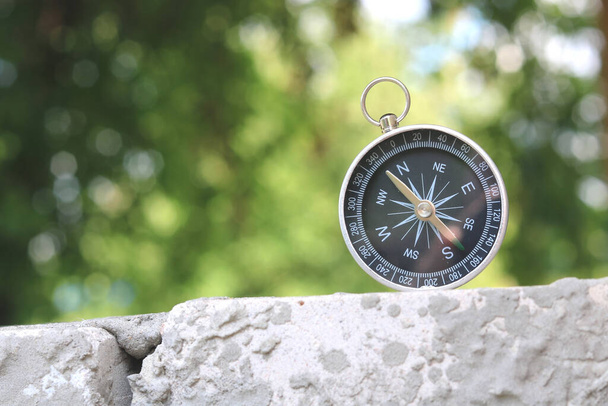 Klasyczny kompas nawigacyjny na naturalnym tle jako symbol turystyki z kompasem, podróże z kompasem i zajęcia na świeżym powietrzu z kompasem - Zdjęcie, obraz