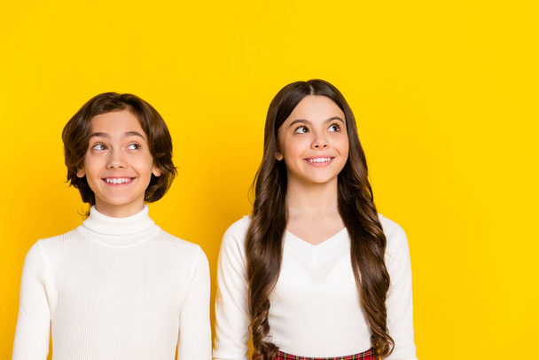 Photo portrait of children smiling dreamy looking empty space isolated on vivid yellow color background - Φωτογραφία, εικόνα