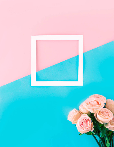 Weißer Kasten mit Platz für Text. Bouquet von zartrosa Rosen. Ästhetik auf blau-rosa Hintergrund. - Foto, Bild