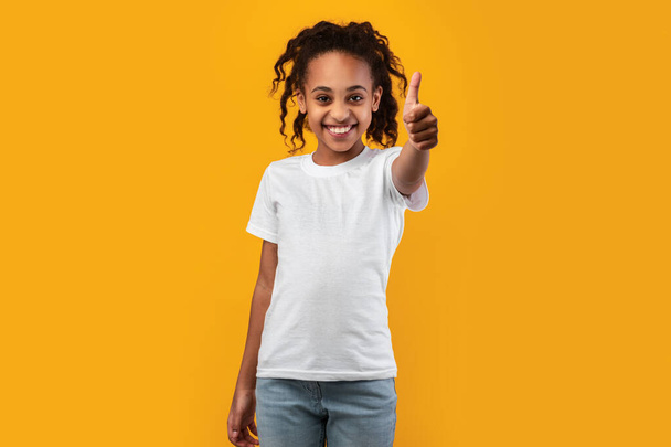 Счастливая чёрная девушка, показывающая большой палец и улыбающаяся - Фото, изображение