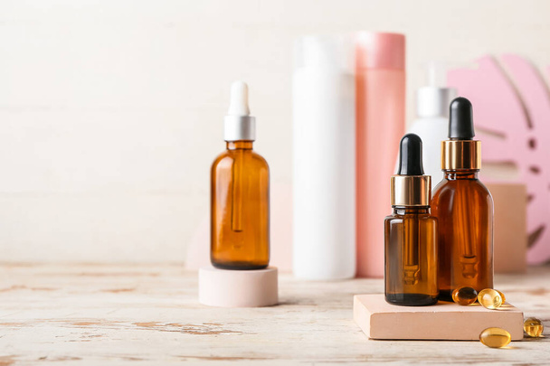 Kozmetikai termékek és tabletták üvegei könnyű fa asztalon, közelkép - Fotó, kép