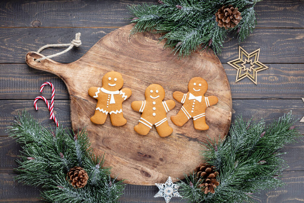 Tasty gingerbread cookies and Christmas decor on wooden background. - Photo, Image