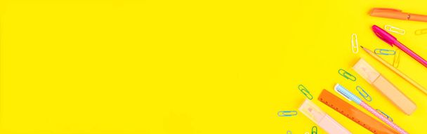 De vuelta al concepto escolar. Coloridas herramientas de escritura banner web sobre fondo amarillo - Foto, imagen