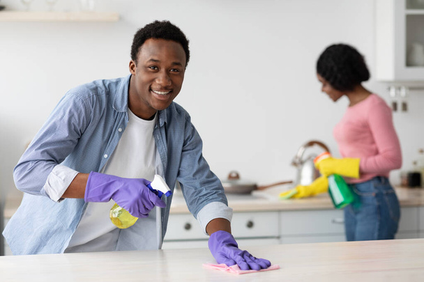 Vrolijke zwarte man en dame schoonmaken van hun nieuwe huis - Foto, afbeelding