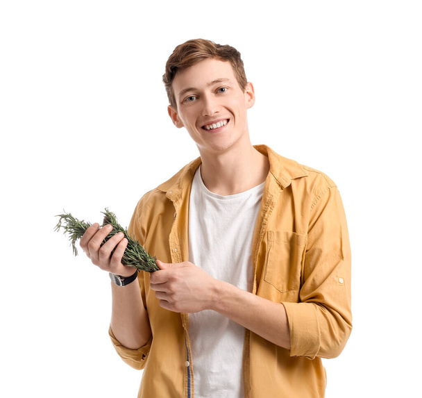 Young man with fresh rosemary on white background - Foto, Bild