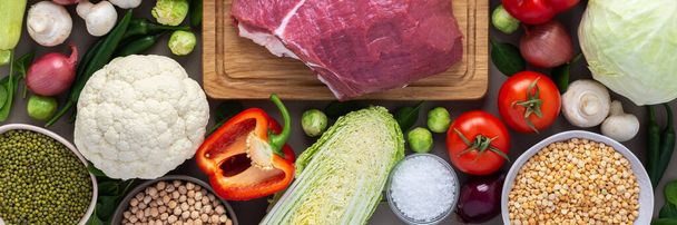 Fresh farm organic vegetables banner, healthy food concept, vegetables and mushrooms, superfoods and beans around the board with a large fresh piece of beef fillet, top view - Photo, Image