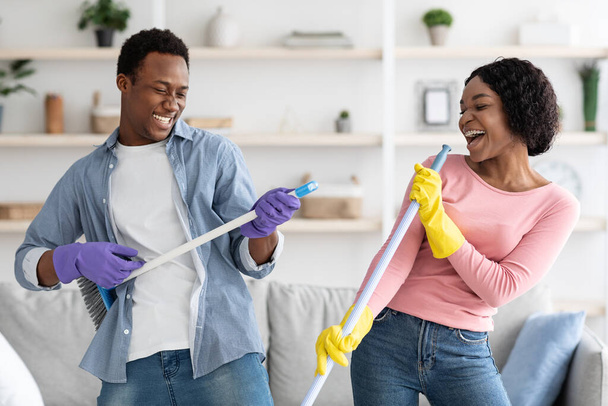 Zabawna afrykańska rodzina bawiąca się podczas sprzątania mieszkania, zbliżenie - Zdjęcie, obraz