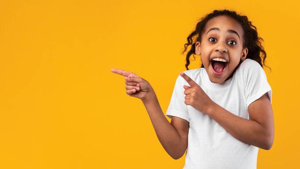 Garota negra excitada apontando para o espaço livre cópia - Foto, Imagem