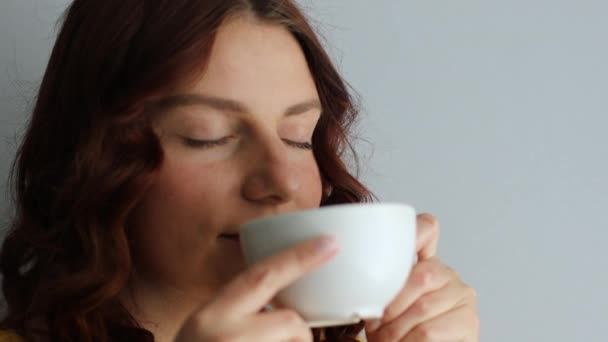 Mujer feliz y positiva tomando un sorbo de café de taza de bebida en la mañana - Metraje, vídeo