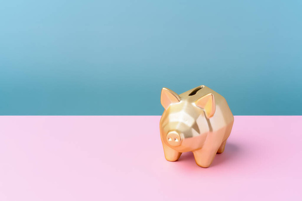 Gold piggy bank isolated on pink and blue background. safe and financial - Foto, Imagem