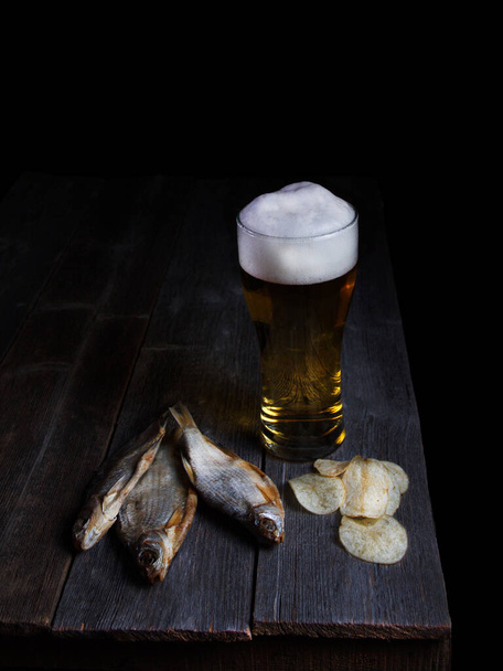 Beer and fish, snacks for beer on a wooden table - Photo, Image