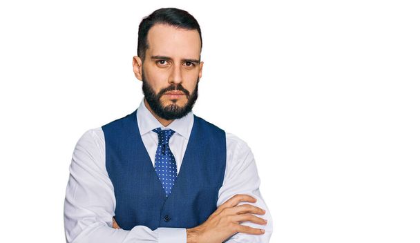 Young man with beard wearing business vest skeptic and nervous, disapproving expression on face with crossed arms. negative person.  - Photo, Image