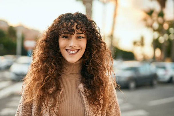 Genç İspanyol kadın gülümseyerek şehirde mutlu mesut dikiliyor. - Fotoğraf, Görsel