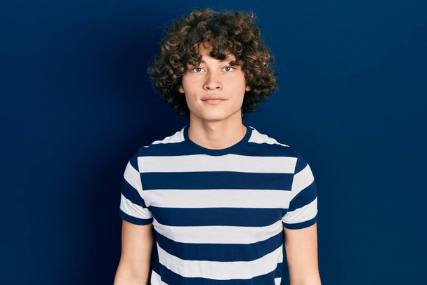 Handsome young man wearing casual striped t shirt relaxed with serious expression on face. simple and natural looking at the camera.  - Photo, image