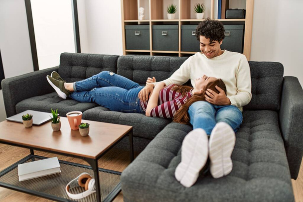 Молода пара усміхнений щасливий розслаблений сидить на дивані вдома
. - Фото, зображення