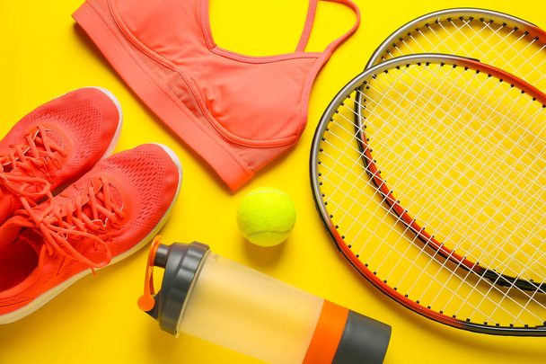 Spor ayakkabısı, top, su şişesi, tenis raketi ve renkli arka plan topu, yakın plan. - Fotoğraf, Görsel