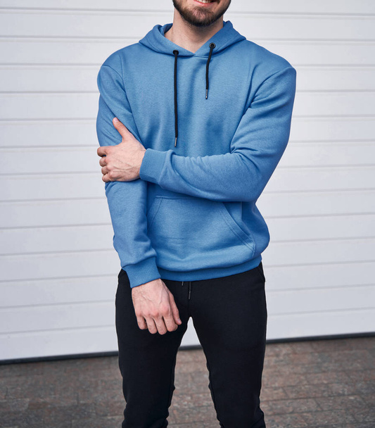 Bearded man standing in azure hoodie. Light blue sweatshirt without a logo. Design mockup - Fotoğraf, Görsel