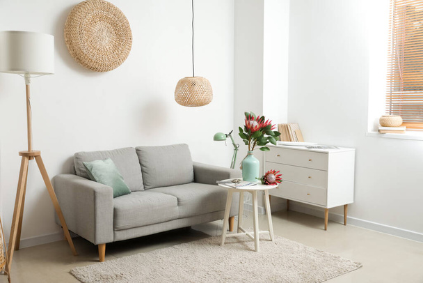 Quarto moderno com cômoda, sofá e flores de protea - Foto, Imagem