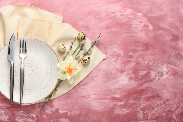 Schöne Tischdekoration mit Narzissenblüte und Eiern auf farbigem Hintergrund - Foto, Bild