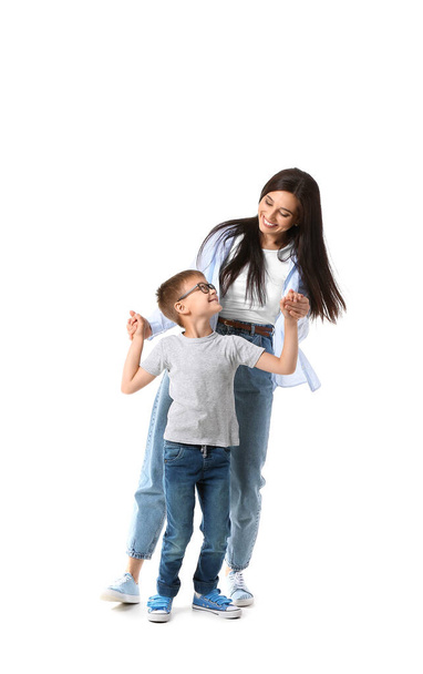 Bailando joven mujer y su pequeño hijo sobre fondo blanco - Foto, imagen