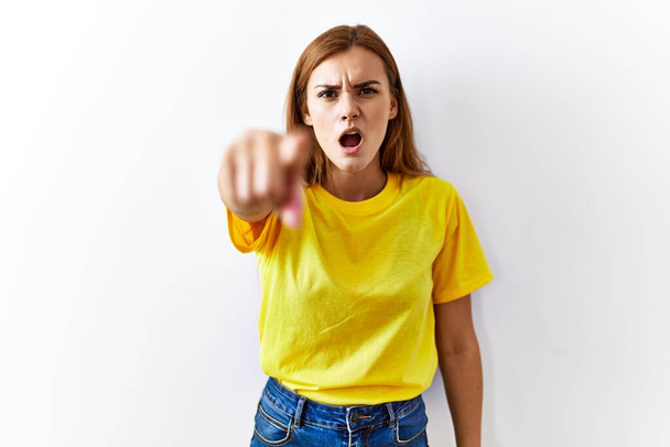 Young brunette woman standing over isolated background pointing displeased and frustrated to the camera, angry and furious with you  - Fotoğraf, Görsel