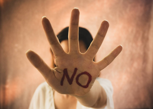 Frau zeigt mit der Hand einen Text mit dem Wort "Nein" und ein Stoppschild - Foto, Bild