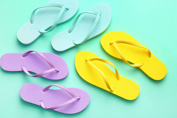 Set of stylish flip-flops on color background - Foto, imagen