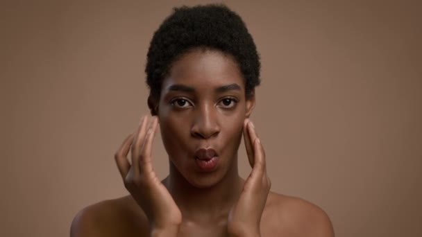 afroamericano signora making facebuilding massaggio sorridente oltre beige sfondo - Filmati, video