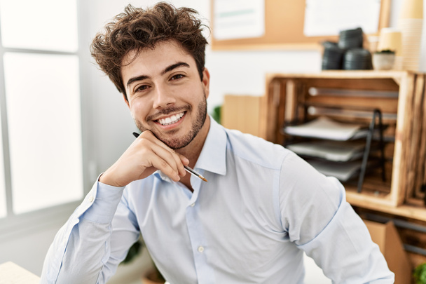 Jovem empresário hispânico sorrindo feliz trabalhando no escritório. - Foto, Imagem