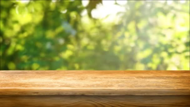 Empty wooden table with fresh green defocused background - Materiaali, video