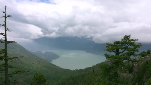 Sis, dağlar ve ormanlarla çevrili göl gizemlerle doludur. Squamish, B.C., Kanada 'daki teleferik istasyonundan çekim gözcüsü manzarası. Haziran 2019. - Video, Çekim