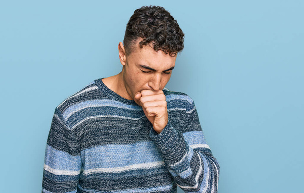 Der hispanische junge Mann in lässiger Kleidung fühlt sich unwohl und hustet als Symptom für Erkältung oder Bronchitis. Gesundheitskonzept.  - Foto, Bild