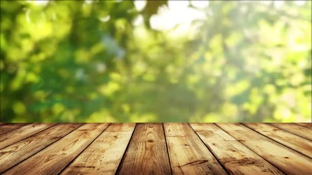 Empty wooden table with fresh green defocused background - Séquence, vidéo