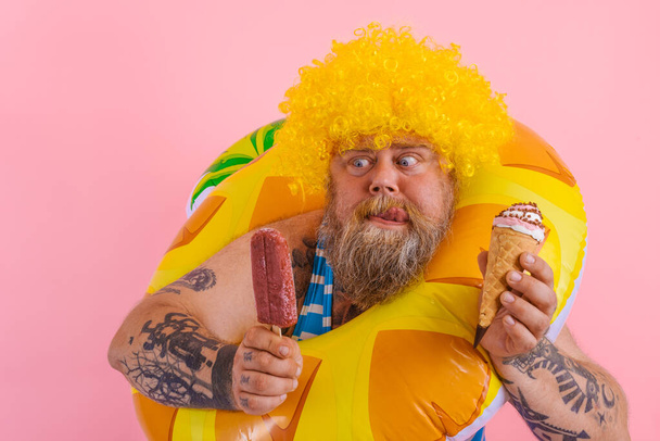 Dikke man met baard en pruik eet een ijsje en een ijsje - Foto, afbeelding