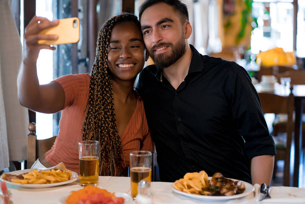 Young couple taking a selfie with a mobile phone during a date. - Foto, Imagen
