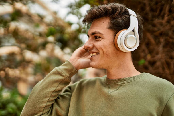 Young hispanic man smiling happy using headphones at the city. - Фото, зображення