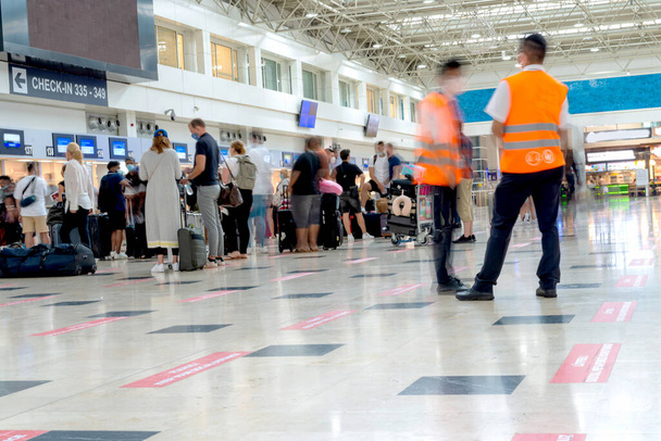Wazig foto - een rij mensen met bagage bij de receptie op de internationale luchthaven - Foto, afbeelding