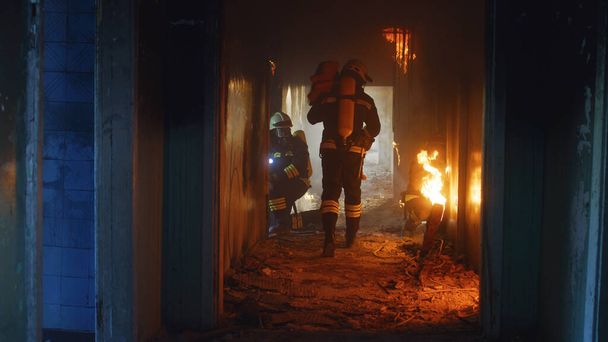 Brandweermannen die door vuur rennen en op zoek zijn naar overlevenden - Foto, afbeelding