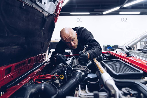 Человек-работник по ремонту или регулированию двигателя - Фото, изображение