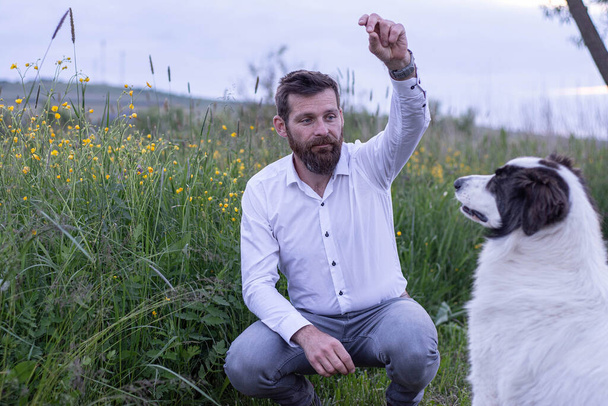 бизнесмен на природе со своей собакой - Фото, изображение