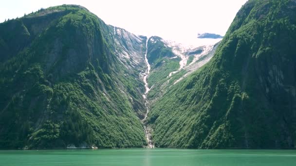Mały wodospad utworzony po stopieniu śniegu. Nad jeziorem, żeby zobaczyć góry lodowe. Fiordy Alaski, unikalne krajobrazy przyrodnicze. Alaska, USA. czerwiec 2019. - Materiał filmowy, wideo